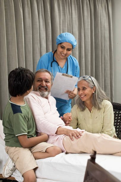 female nurse and family with senior patient sitting on bed